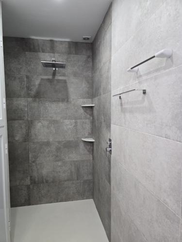 a bathroom with a shower with gray tiles at Southbay Alquiler in San Fernando