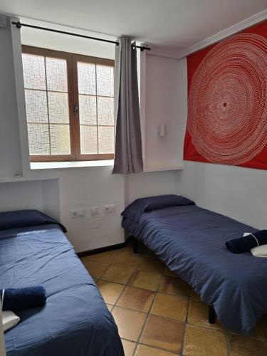a room with two beds and a painting on the wall at Southbay Alquiler in San Fernando