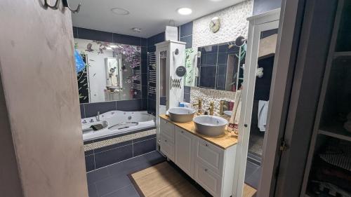 a bathroom with two sinks and a bath tub at Chez igor in Pétange