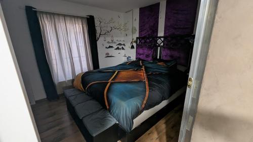 a bedroom with a large bed with purple accents at Chez igor in Pétange