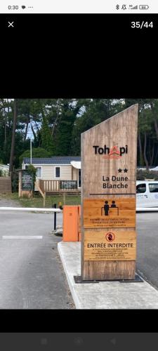 a wooden sign on the side of a street at Lieu de paix in Camiers