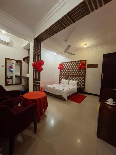 a bedroom with a bed and a red table at Kuti Hotel Stone Town in Ngambo