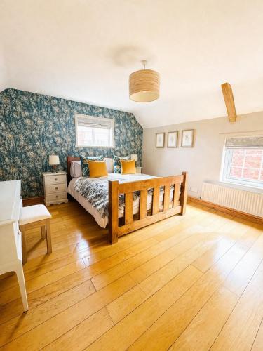 a bedroom with a bed and a wooden floor at The Old Ropery at Mill Cottage - Sherwood Forest in Ollerton