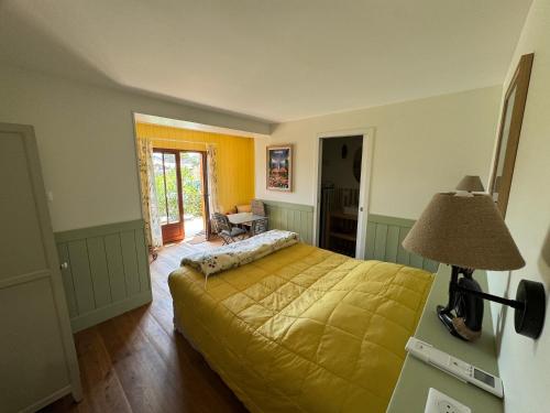 a bedroom with a bed with a yellow bedspread at Cabanon Régina in Lège-Cap-Ferret
