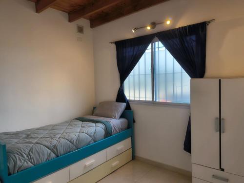 a bedroom with a bed and a window at ÁMBAR DEPARTAMENT boutique in Monte Grande