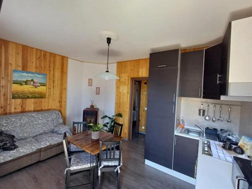 a kitchen and a living room with a couch and a table at Eva House 2 in Fanano