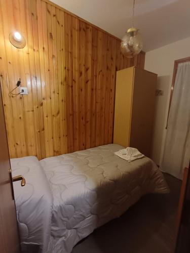 a bedroom with a bed and a wooden wall at Eva House 2 in Fanano