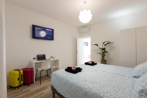 a bedroom with a bed and a desk with a computer at Gradisca Go Home 2 in Gradisca dʼIsonzo