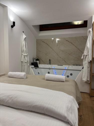 a bedroom with two beds and a bath tub at EPICENTAR Luxury Jacuzzi & Sauna Apartment in Baščaršija - Private Spa Experience in Sarajevo