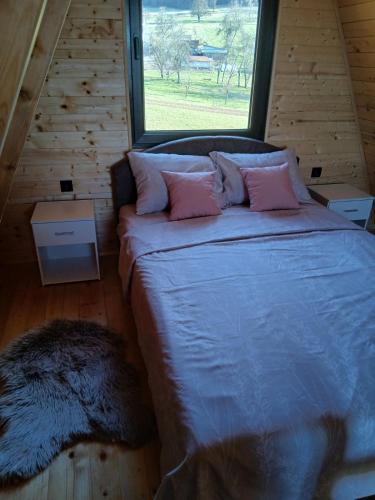 a bedroom with a large bed with a large window at Vikendica Bogdanović in Nova Varoš