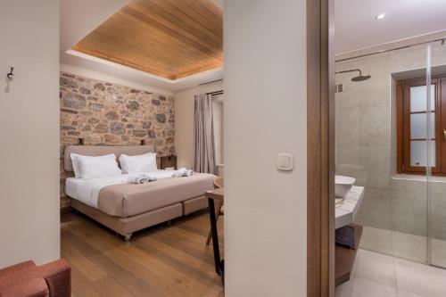 a bedroom with a bed and a sink and a bathroom at Μikri Arktos Boutique Hotel in Dimitsana