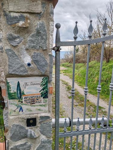 a sign on a stone wall next to a gate at La Capanna in Radicofani