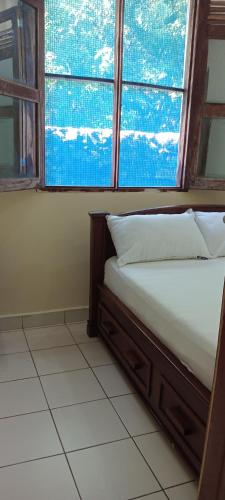 a bed in a room with a large window at Perfect Backpacker Spot in Shimoni