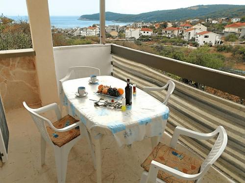 a white table and chairs on a balcony with a view at Apartments Boa in Slatine