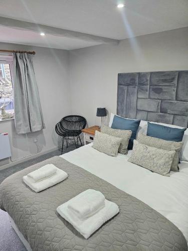 a bedroom with a large bed with two towels on it at Last Yan - Stylish Ambleside Stay in Ambleside