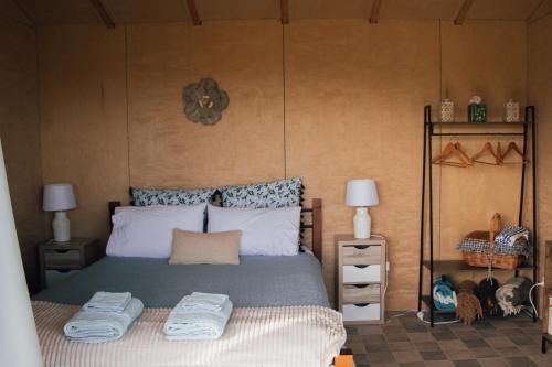 a bedroom with a bed with towels on it at HavenRidge Alpaca Glamping Cabins in Kaiwaka