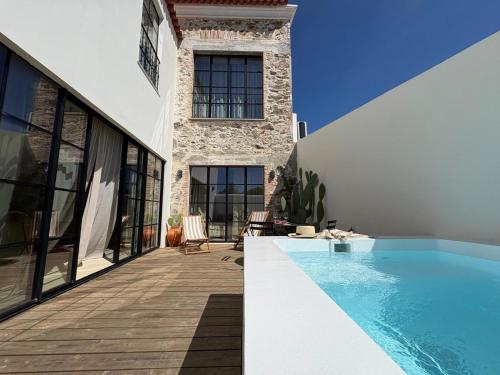 a house with a swimming pool next to a building at Casa Amanhada Apartamento Zero in Grândola