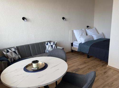 a living room with a coffee table and a bed at Cloud 12 - Penthouse in der Innenstadt mit Blick über die gesamte Skyline von Bremerhaven in Bremerhaven