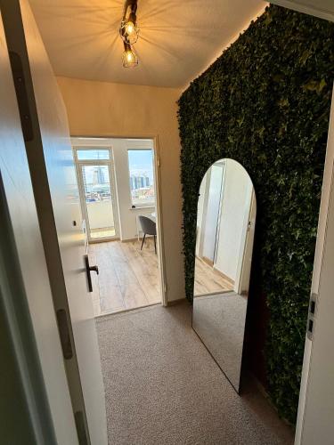 a hallway with a mirror next to a wall at Cloud 12 - Penthouse in der Innenstadt mit Blick über die gesamte Skyline von Bremerhaven in Bremerhaven