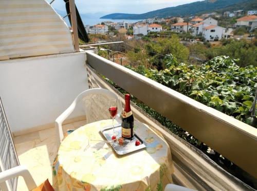 a bottle of wine sitting on a table on a balcony at Apartments Boa in Slatine