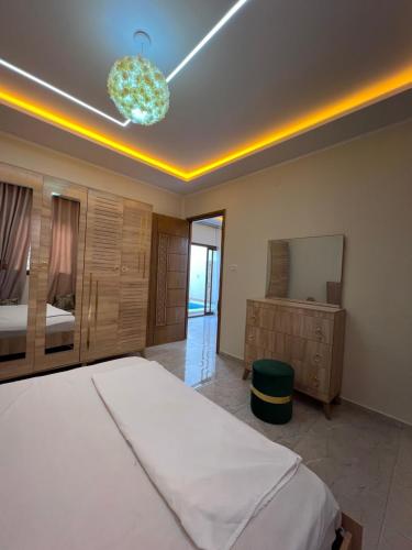 a bedroom with a bed and a mirror and a chandelier at Dar anas in Fafou