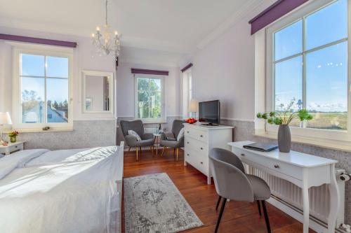 a bedroom with a bed and a desk with a computer at Boutique Hotel Villa Wahnfried Thiessow in Thiessow