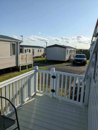a white deck with a car parked in a parking lot at Holiday Sea Caravan in Withernsea