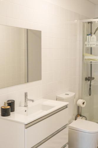a white bathroom with a sink and a toilet at Dolce Vita Heroismo in Porto