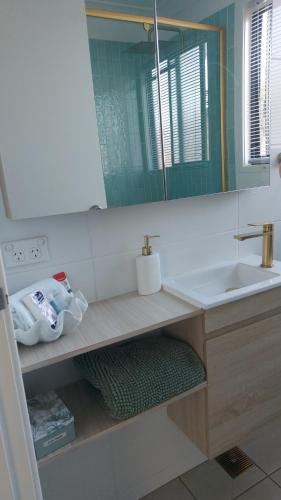 a bathroom with a sink and a mirror at Stay Breezy in Erowal Bay