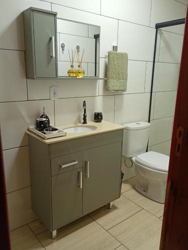 a bathroom with a sink and a toilet at Cabana mandaçaia in Timbe do Sul