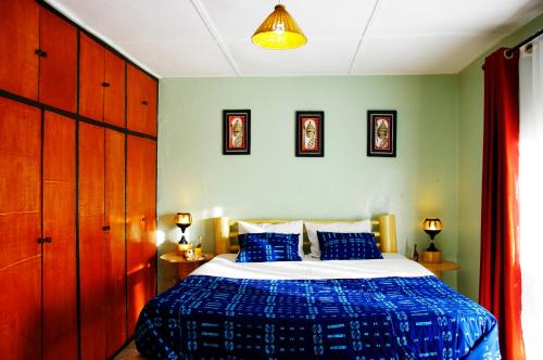 a bedroom with a bed with blue sheets and blue pillows at Spa Elpis in Kigali