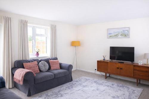 a living room with a couch and a flat screen tv at Oxford Cottage in Wheatley - Parking & Garden in Wheatley