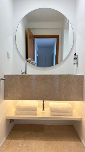 a bathroom with a sink and a mirror at Apartamentos Rossio Mar in Albufeira