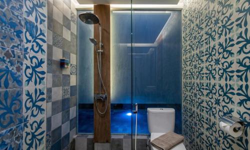 a blue bathroom with a shower and a toilet at Sari Dana Villas in Sanur