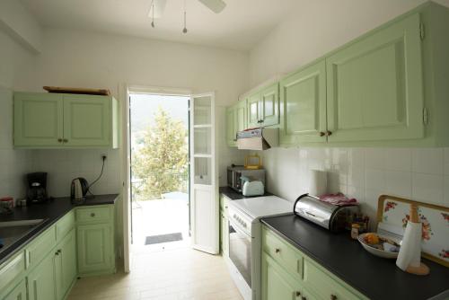 a kitchen with green cabinets and an open door at Costa's House in Kiónion