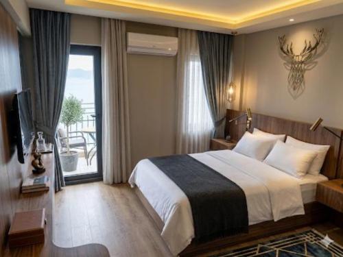 a bedroom with a large bed and a large window at Aqua Princess Hotel in Kaş