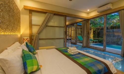 a bedroom with a bed and a swimming pool at Sari Dana Villas in Sanur