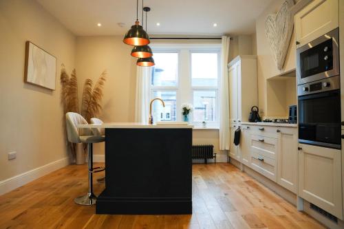 a kitchen with a island in the middle of a kitchen at Modern 2 Bed 2 Bath Apartment in Prime Jesmond Location in Newcastle upon Tyne