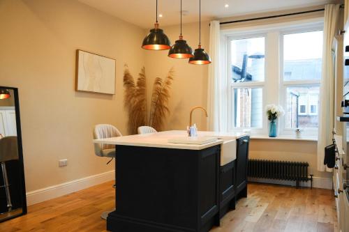 a kitchen with a black island with a sink at Modern 2 Bed 2 Bath Apartment in Prime Jesmond Location in Newcastle upon Tyne