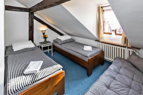 a small room with two beds and a couch at Penzion Landauer in Český Krumlov