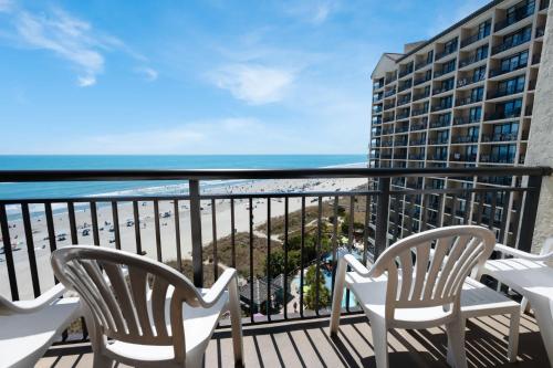 a balcony with chairs and a view of the beach at Amazing Oceanfront Accessible Beach Amazing View in Myrtle Beach