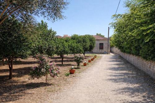 a dirt road with trees and a brick wall at Villa Mesiano in Polistena