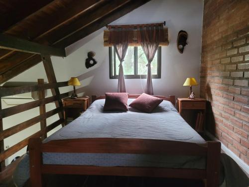 a bedroom with a bed with two pillows on it at Cabañas Desde Las Estrellas in Merlo