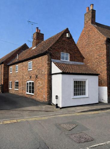 a red brick building with a white garage at The Old Ropery at Mill Cottage - Sherwood Forest in Ollerton