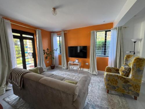 a living room with a couch and a tv at Prime Elgon View 5BR Family Home Private Secure in Eldoret
