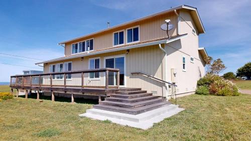 a house with a porch and stairs in front of it at Dog Friendly Oceanfront Home with Hot Tub & Views in Fort Bragg