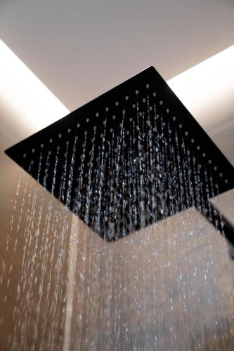 a shower with a bunch of bottles of water at ART&SPA Koblenz in Koblenz