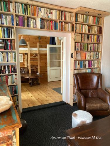a living room with book shelves filled with books at Cottage Scandi Dedinky in Dedinky