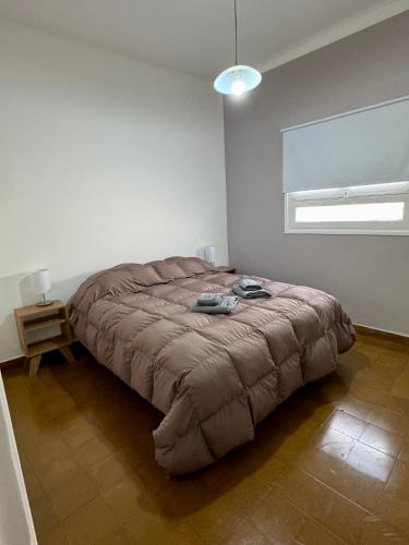 a bedroom with a large bed in a white room at Departamento Lavanda in San Juan