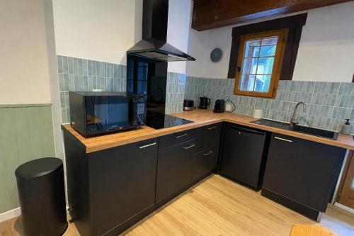 a kitchen with black cabinets and a sink at Maison Bayle in Vignec